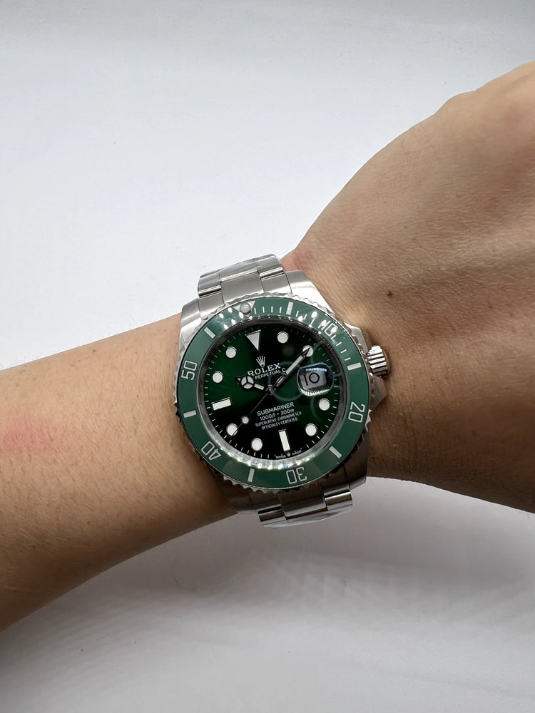 Relógio Rolex Submariner no pulso, mostrador verde e luneta com marcações