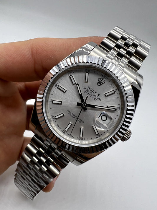 Relógio Rolex prateado com mostrador cinza claro e pulseira metálica, em ângulo.