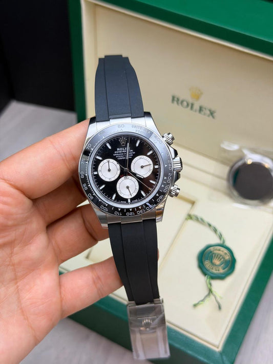 Relógio Daytona prateado com mostrador preto, cronógrafos e pulseira azul-marinho