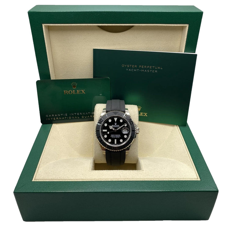 Relógio Rolex automático com mostrador preto e pulseira de borracha preta na caixa.