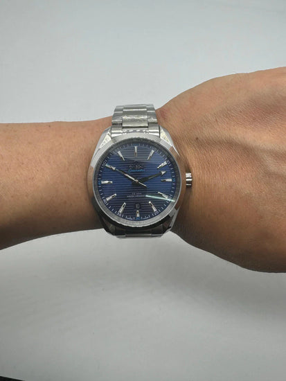 Relógio automático com mostrador azul e pulseira metálica no pulso