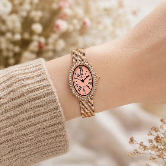 Relógio oval dourado rosé com pulseira de malha e mostrador rosa com algarismos romanos