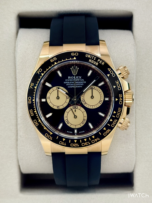 Relógio Daytona com pulseira de borracha azul e mostrador escuro, caixa dourada.