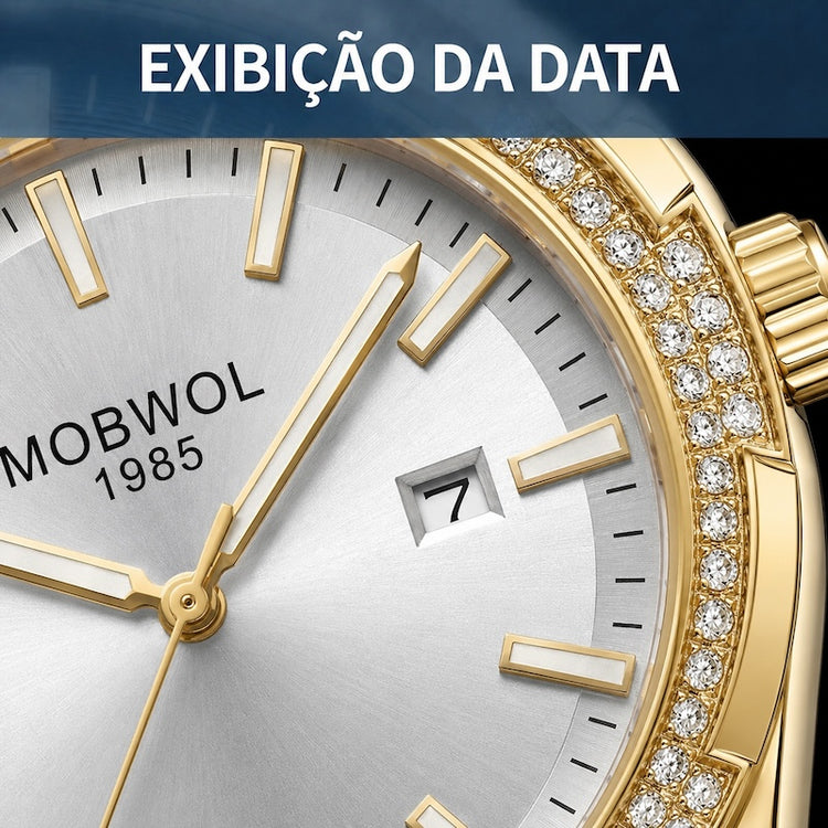 Relógio com mostrador branco e números/batentes dourados; aro cravejado de pedras