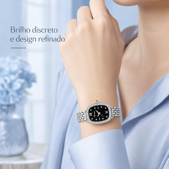 Relógio feminino prateado com mostrador preto e strass no aro, no pulso
