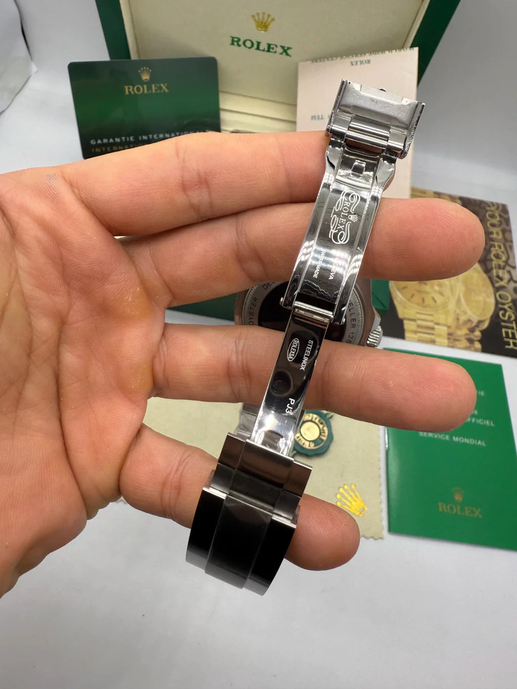 Relógio automático com pulseira de aço e fecho metálico, visto de lado.