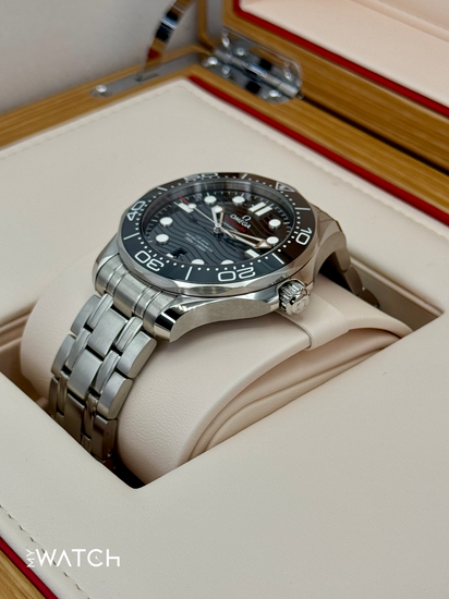 Relógio Omega com mostrador preto, pulseira metálica e coroa lateral, em estojo
