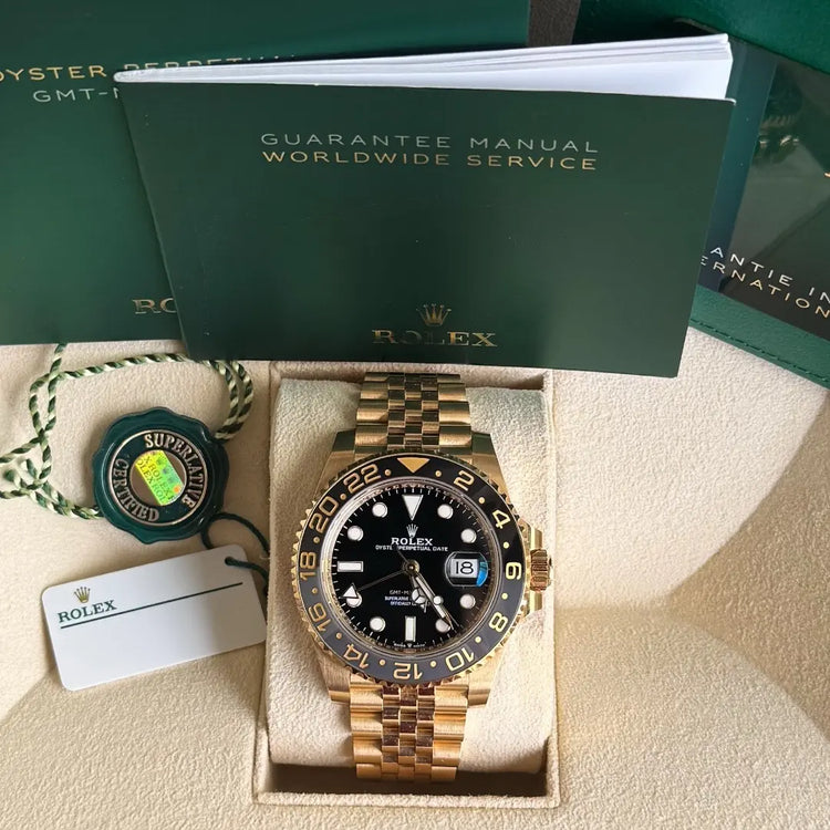 Relógio Rolex GMT Master II com fundo visível e pulseira de elos dourados