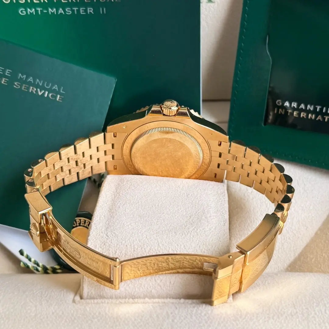 Relógio Rolex GMT Master II com mostrador voltado para cima e pulseira dourada