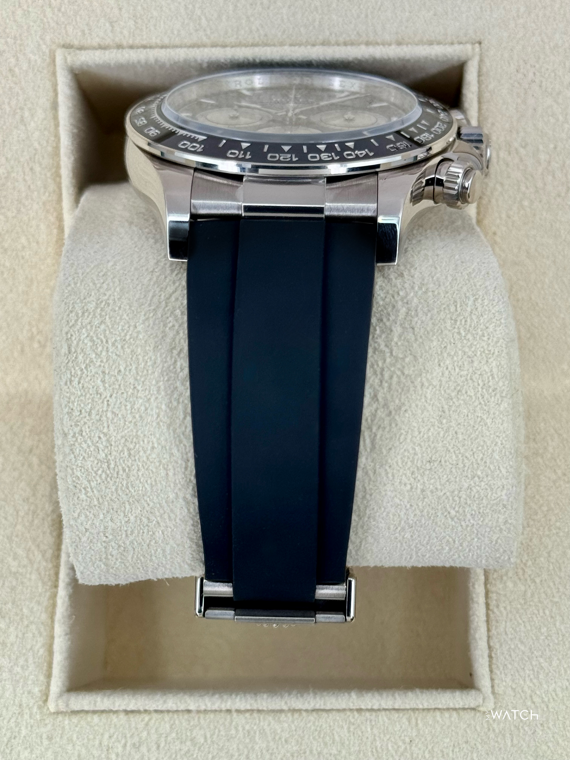 Relógio Daytona prateado com mostrador preto e pulseira azul-marinho na caixa
