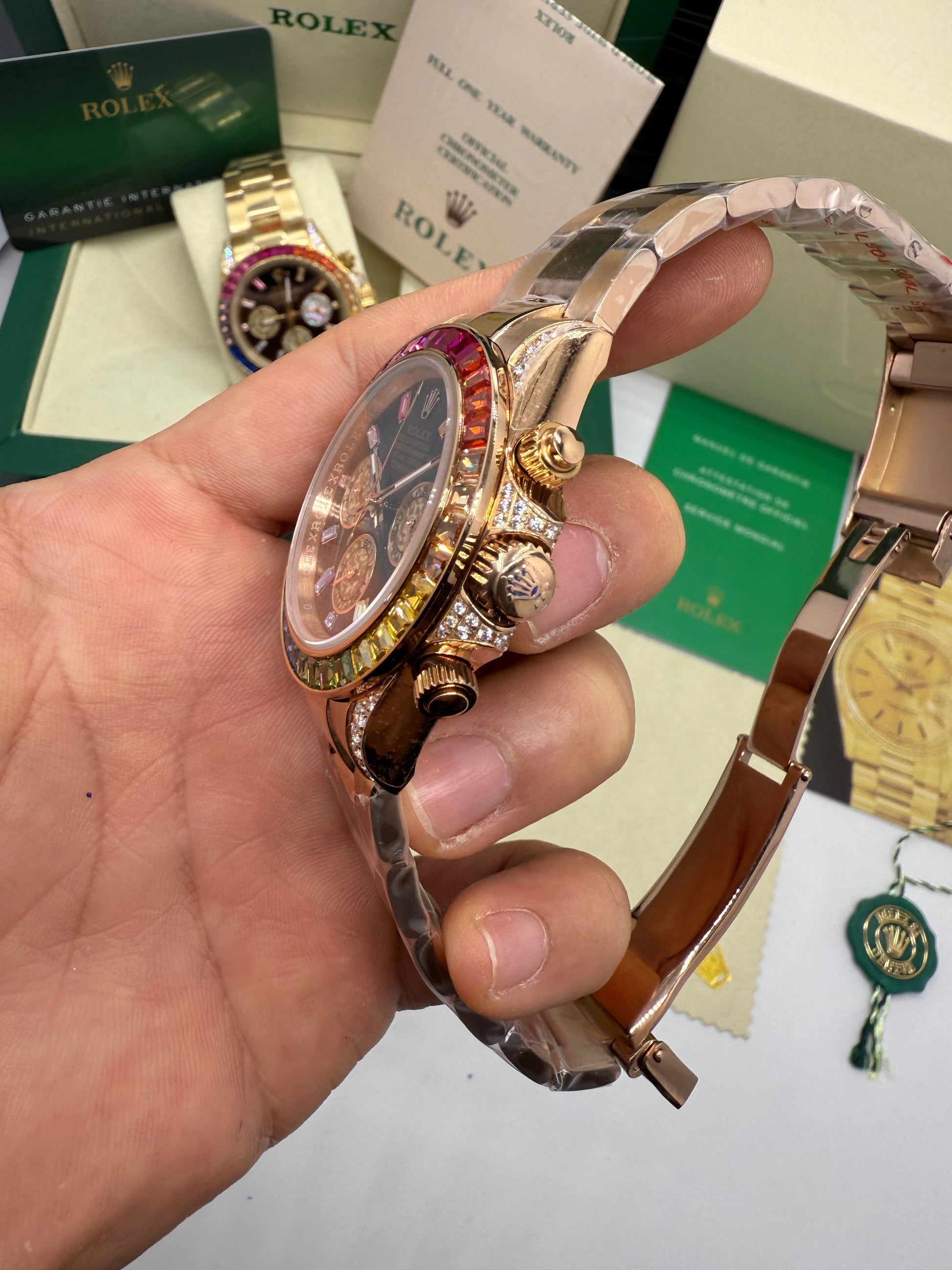 Relógio Daytona com lateral da caixa e botões, coroa visível e pulseira metálica