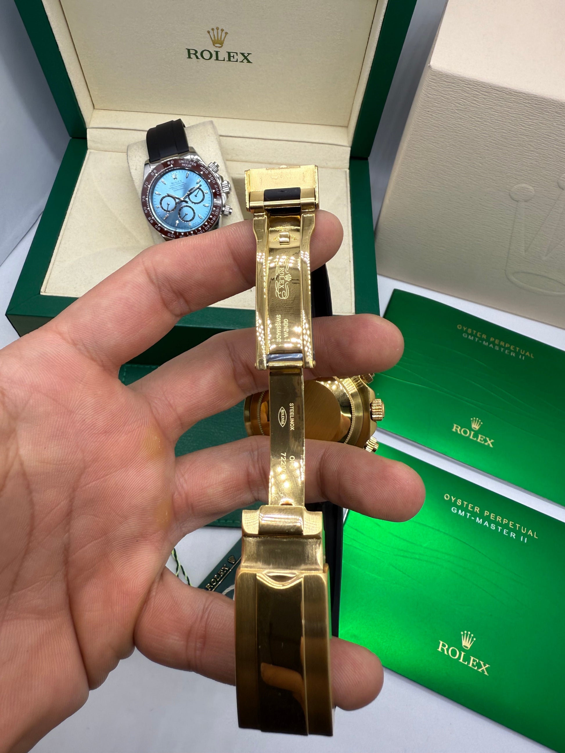 Relógio Rolex Daytona com pulseira dourada e caixa dourada, mostrador azul e coroa.