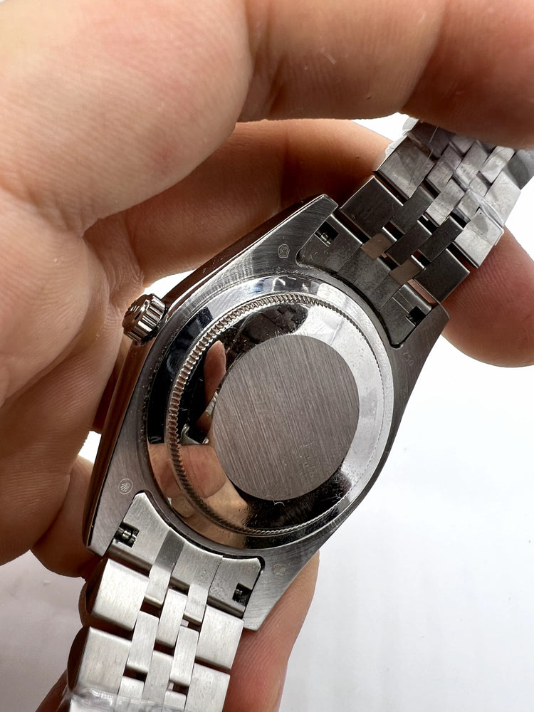 Relógio Rolex com fundo e coroa aparentes e pulseira prateada de elos metálicos