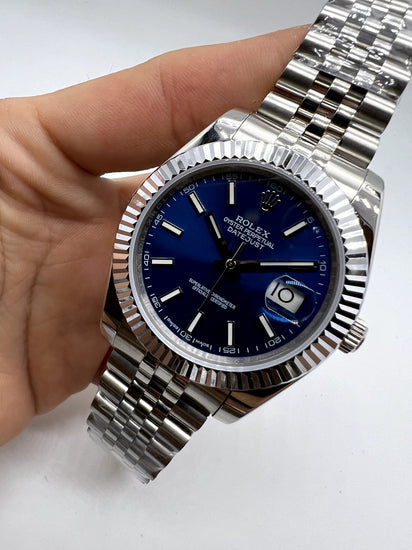 Relógio Rolex com mostrador azul e luneta canelada, pulseira de aço prateada