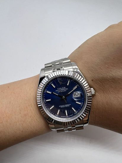 Relógio Rolex Date Just no pulso, mostrador azul e pulseira metálica prateada