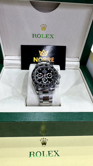 Relógio automático de mostrador preto com pulseira de aço, exibido em caixa