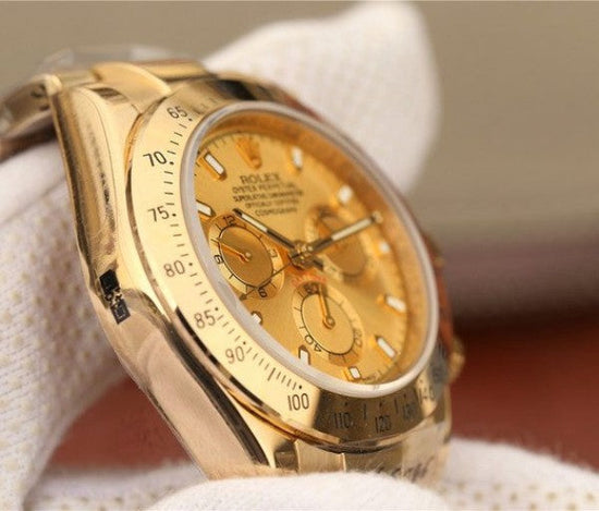 Relógio automático dourado com mostrador creme e pulseira metálica, vista lateral