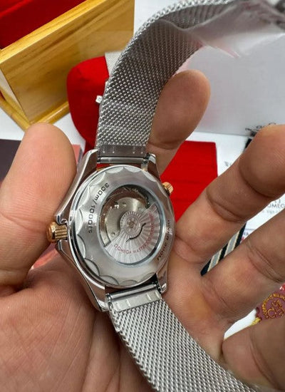 Fundo do relógio automático prateado com gravações e pulseira de malha metálica