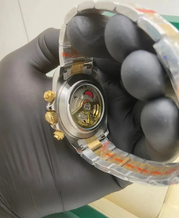 Relógio Rolex Daytona visto de lado, caixa em aço com detalhes dourados e mostrador verde