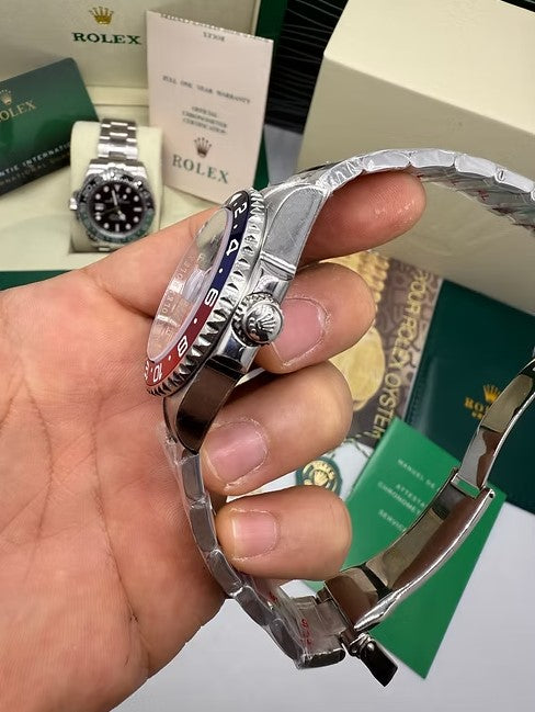 Relógio de pulso em aço, mostrador prateado e bezel azul/vermelho