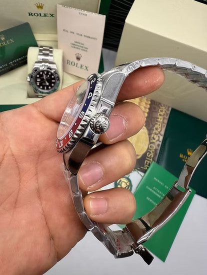 Relógio de pulso em aço, mostrador prateado e bezel azul/vermelho