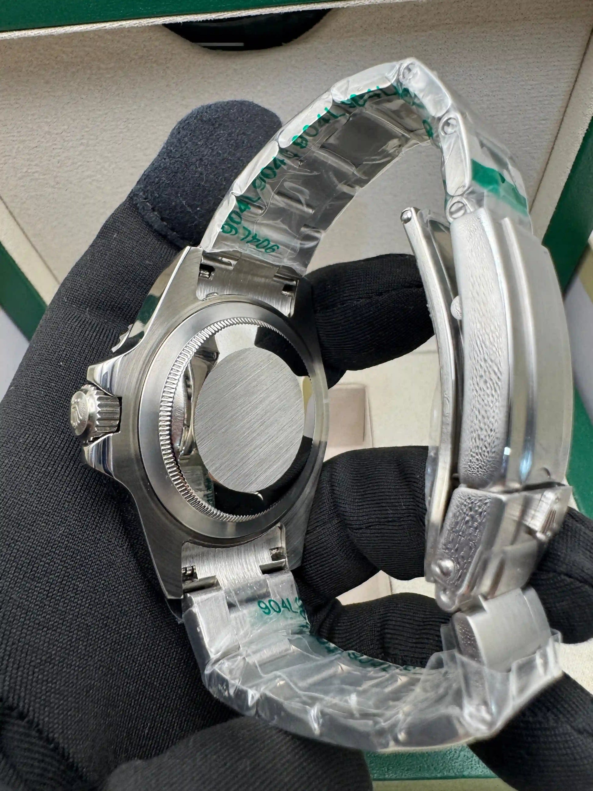 Relógio Rolex Submariner lado com coroa e botões, pulseira de aço, ângulo lateral