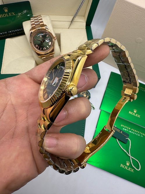 Relógio dourado com coroa e pulseira de metal, vista lateral