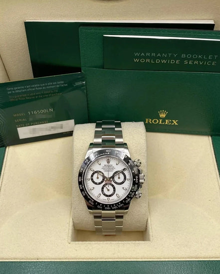 Relógio Rolex automático em caixa com mostrador branco e bezel preta de taquímetro