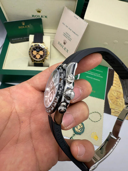 Relógio Rolex Daytona com caixa prateada e coroa, pulseira preta