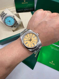 Relógio Rolex com pulseira de aço e mostrador amarelo no pulso, lateral