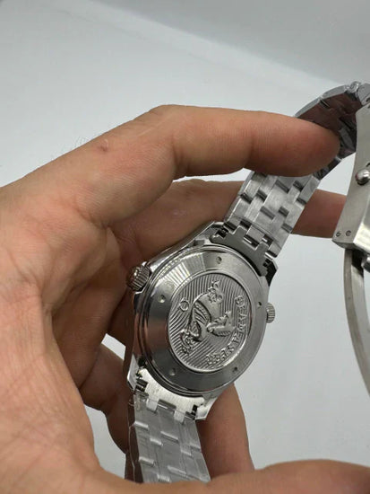 Fundo do relógio Omega em metal com gravação e pulseira metálica prateada