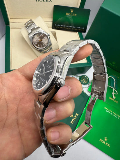 Relógio Rolex com caixa e pulseira de aço, vista lateral com coroa