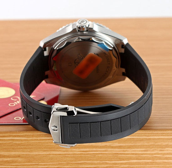 Relógio Omega com pulseira de borracha preta e fecho metálico, fundo do relógio visível