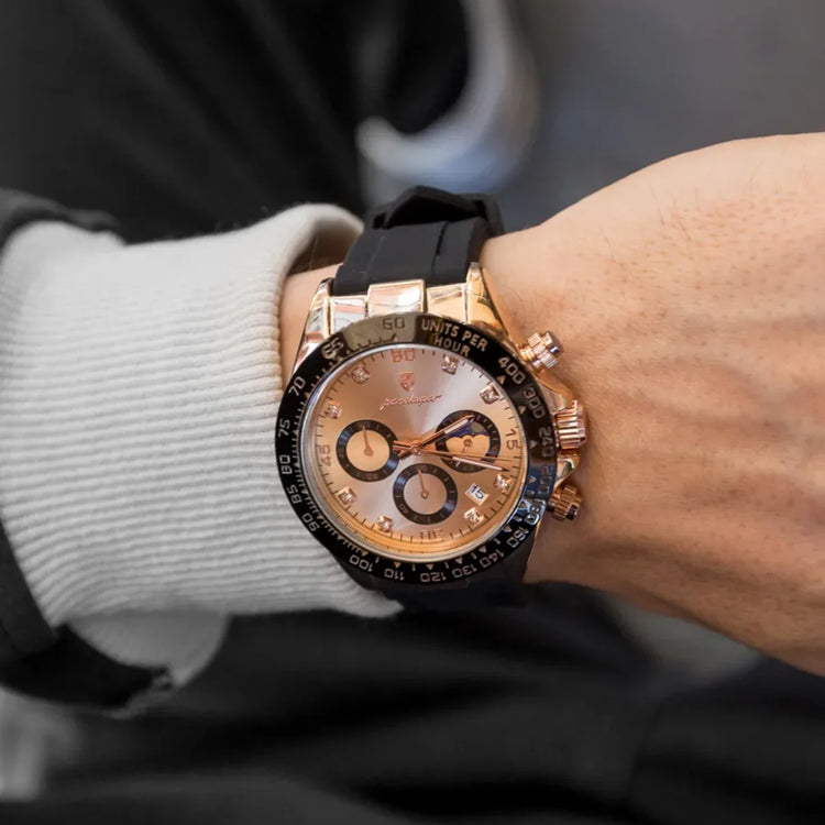 Relógio com caixa bronze e mostrador bege, pulseira preta de silicone.