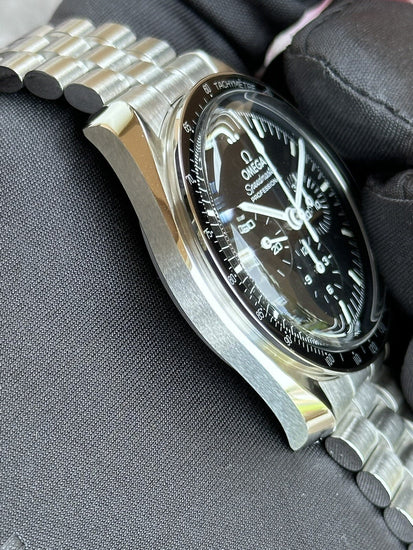 Relógio Omega Speedmaster com caixa de aço e pulseira metálica, vista lateral