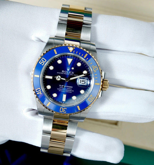Relógio Rolex Submariner com pulseira bicolor e mostrador azul, marcadores e data.