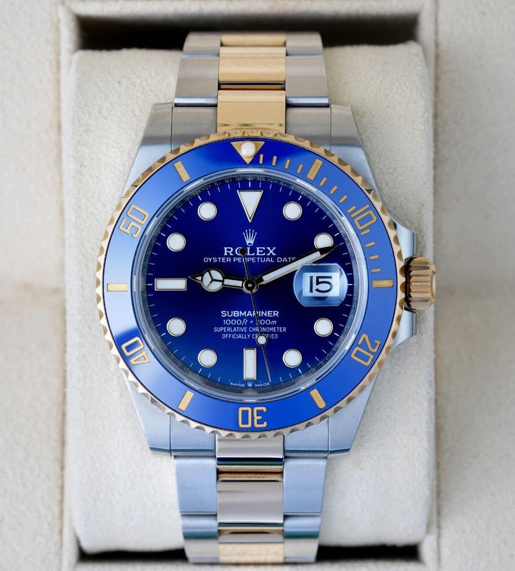 Relógio Rolex Submariner com mostrador azul e janela de data na pulseira bicolor.