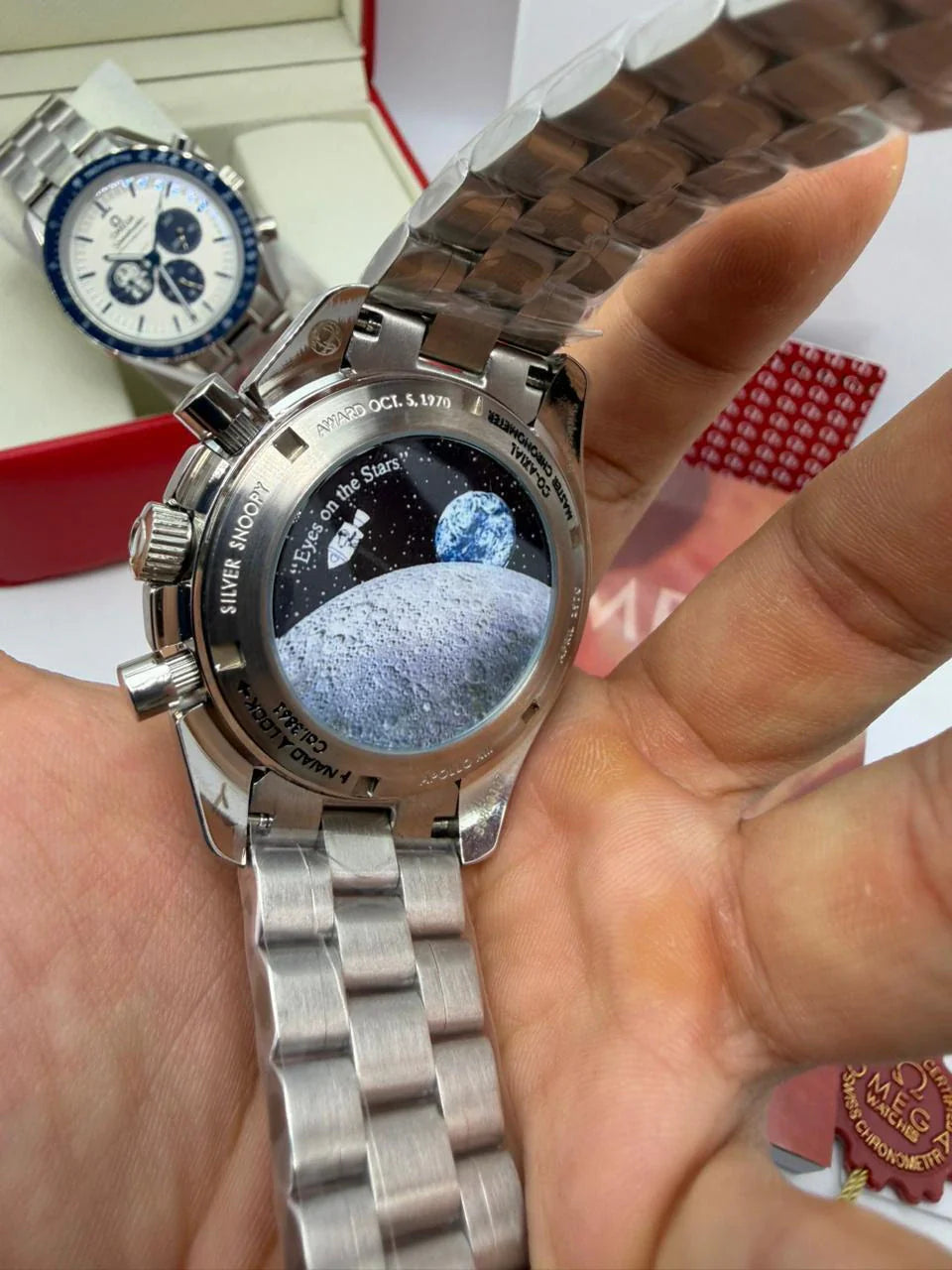 Fundo do relógio Omega Speedmaster em aço com inscrições, pulseira de elos metálicos